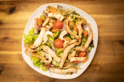 Putenstreifen-Salat mit gegrillten Putenstreifen auf grünem Salat