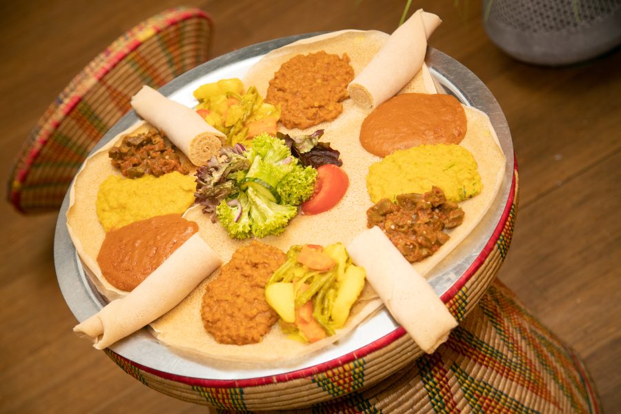 Vegane Platte – vegane Gerichte auf Injera im traditionellen Korbtisch