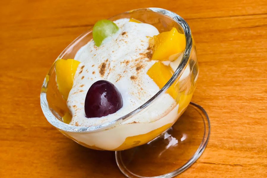 Mango Joghurt mit Mangostücken und Trauben im Glas