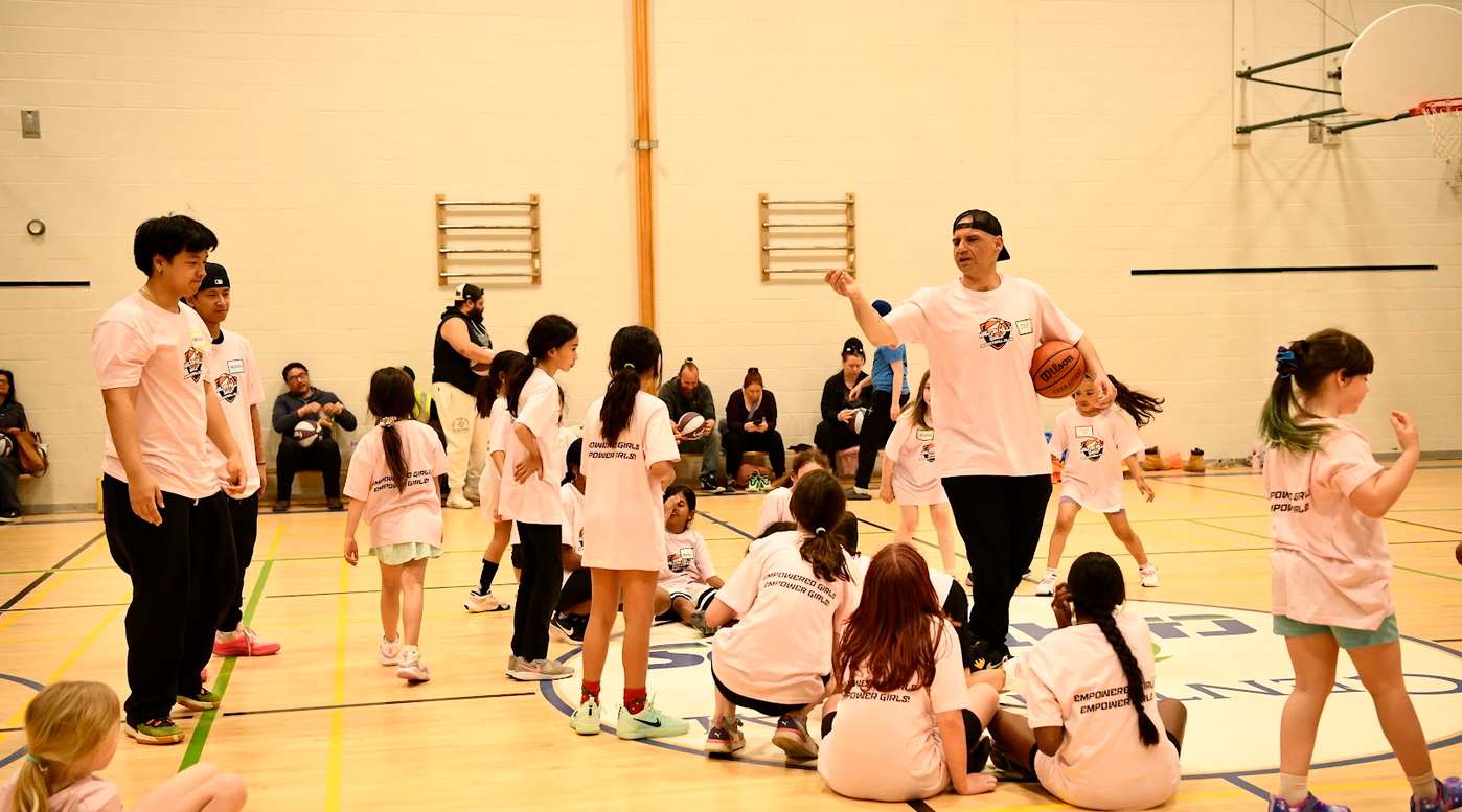 Players watching a basketball go through the hoop in the gym